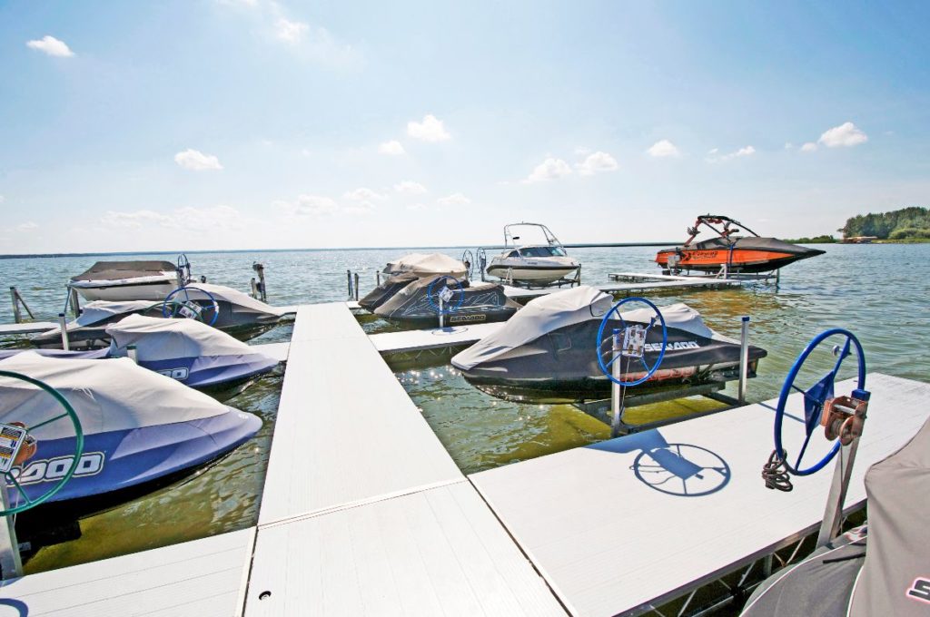 Boats and seadoos parked at a small dock