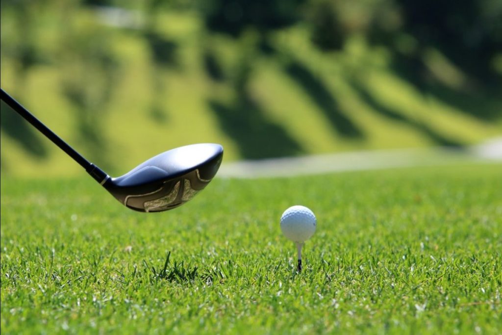 A driver golf club teeing up