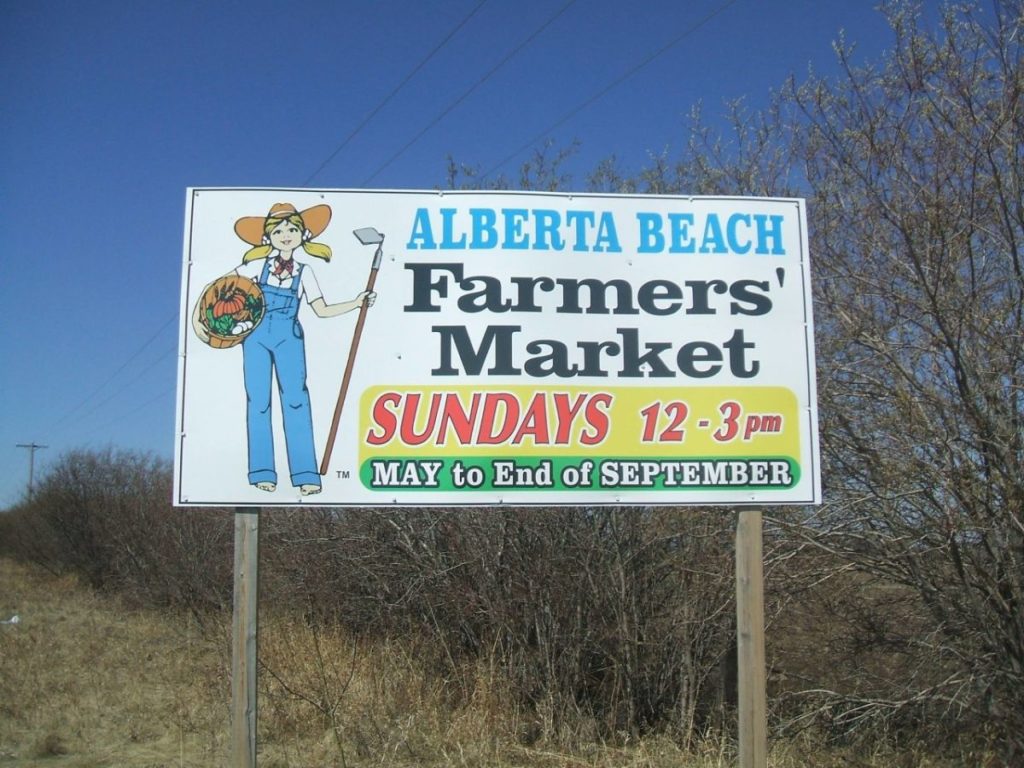 A picture of a road sign advertising the Alberta Beach Farmers market