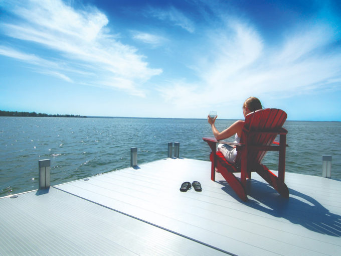 woman sitting in beach chair on dock